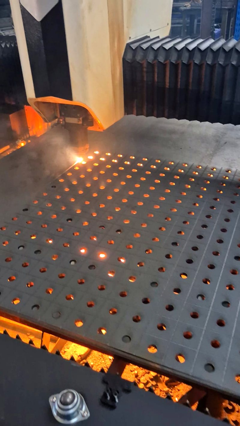 Furos de precis&atilde;o cortados a laser em chapa met&aacute;lica, ainda incandescentes